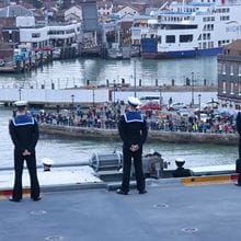 Sailors onboard HMS Queen Elizabeth Stand to attention entering Portsmouth