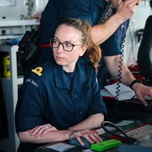 A female sub-lieutenant sits at her desk
