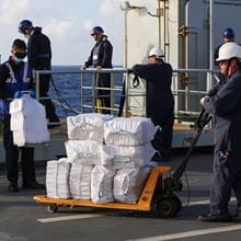 RFA sailors unloading several large white bags of narcotics