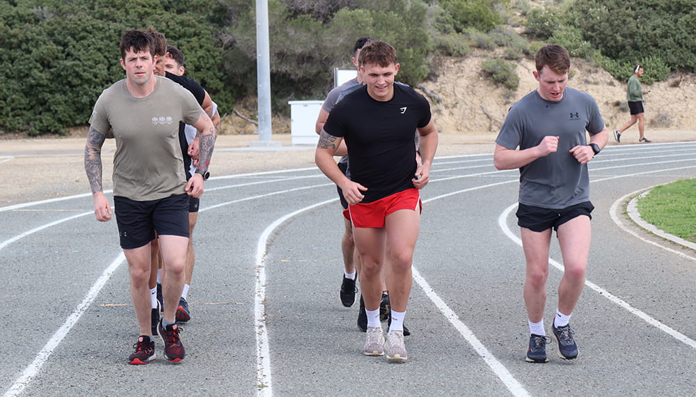 Group of people running training for their Royal Navy fitness tests. 
