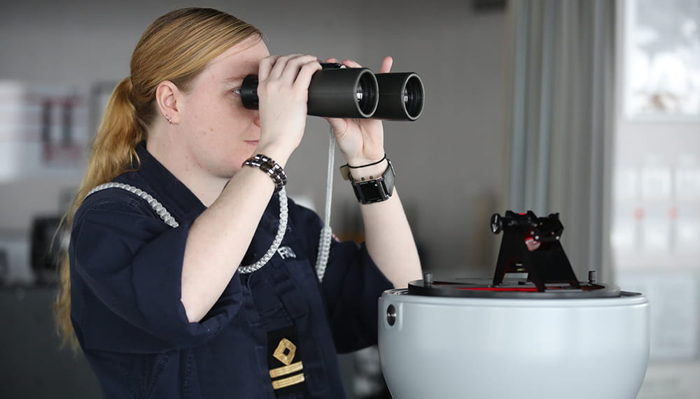 Navy personnel working whilst using binoculars. 