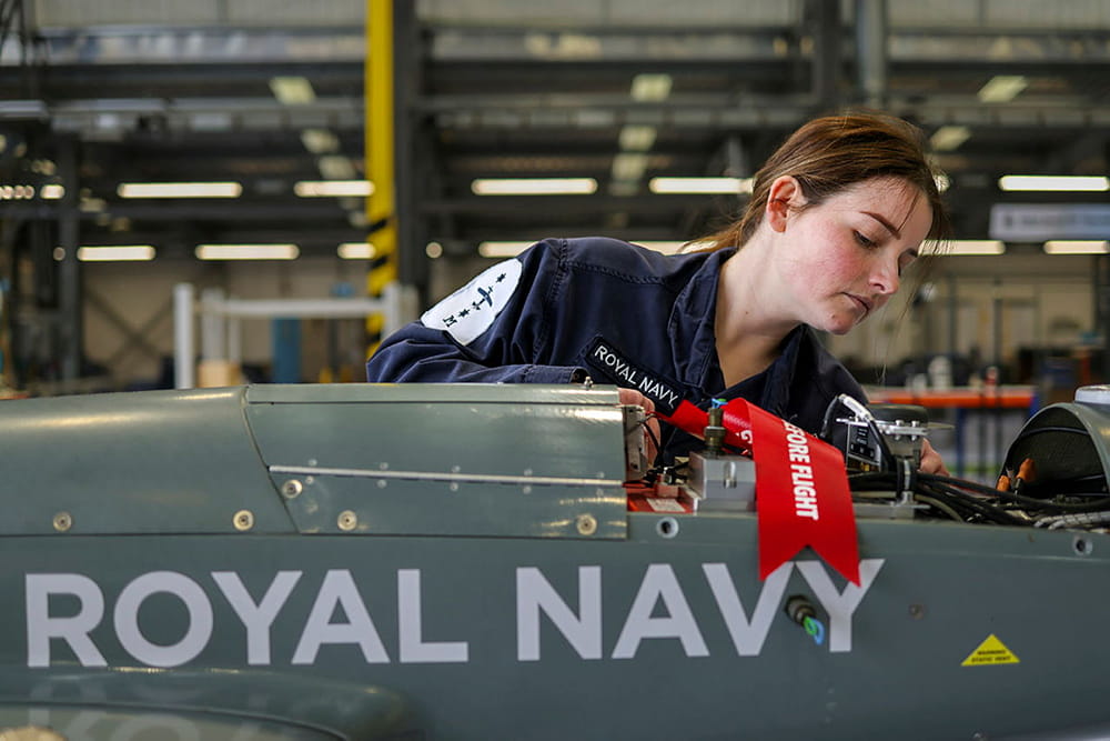 Royal Navy engineer works on a drone in a workshop