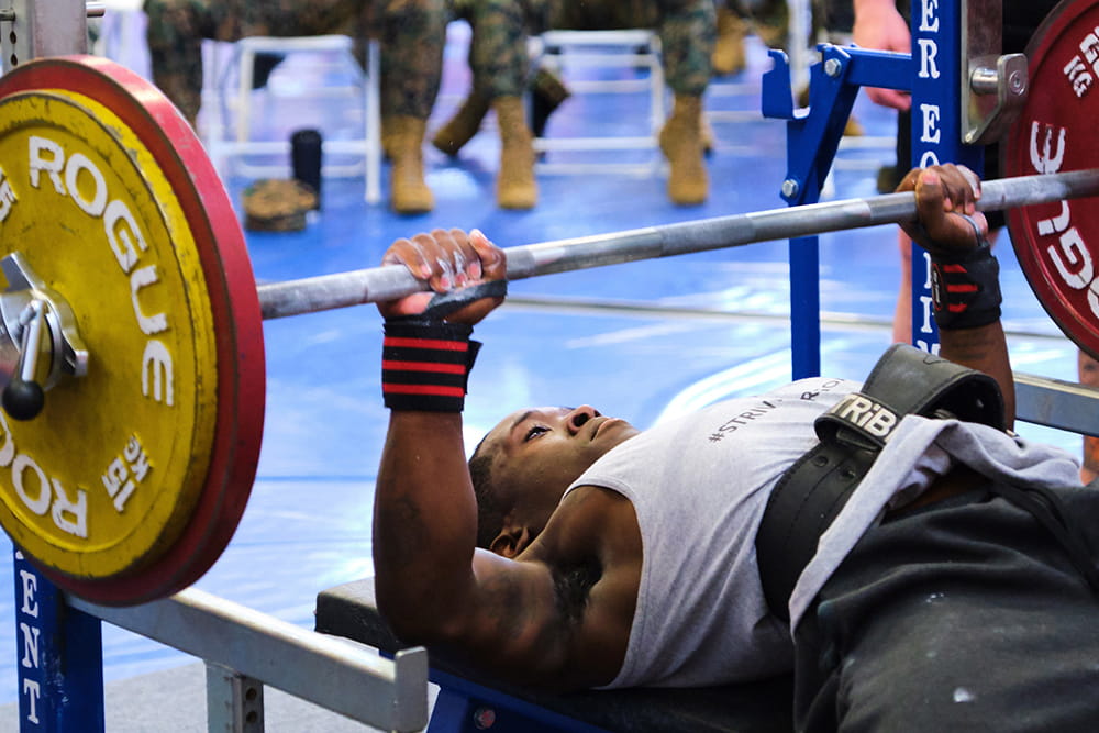 Royal Marines power lifter chest presses a heavy bar