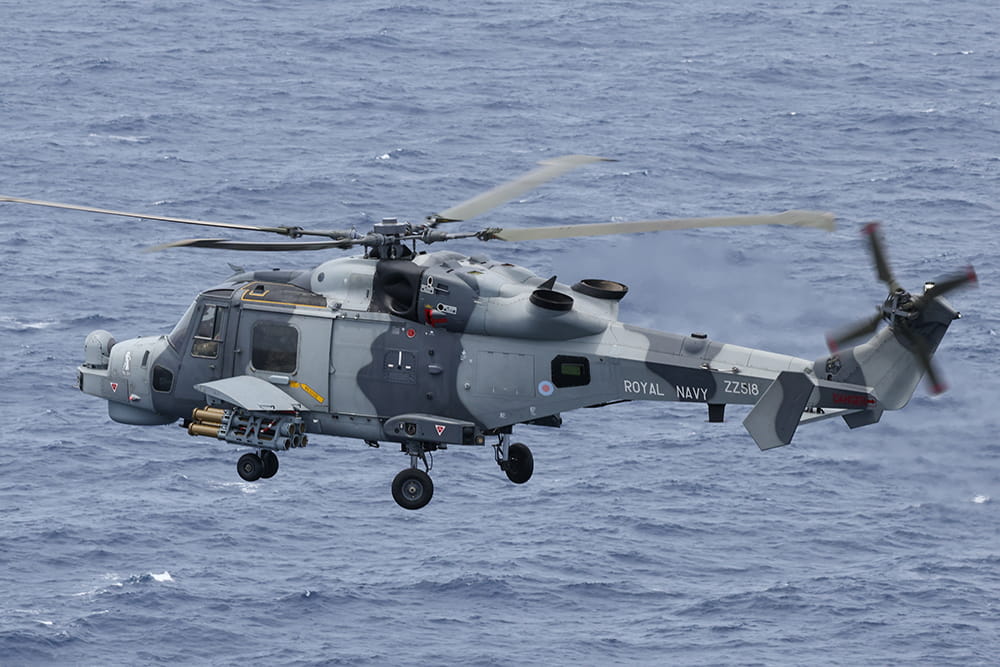 Wildcat in grey camouflage patterned paint flies over the sea