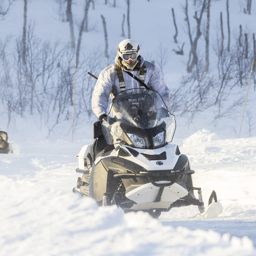 Royal Marine in snow gear in arctic conditions using a snowspeeder