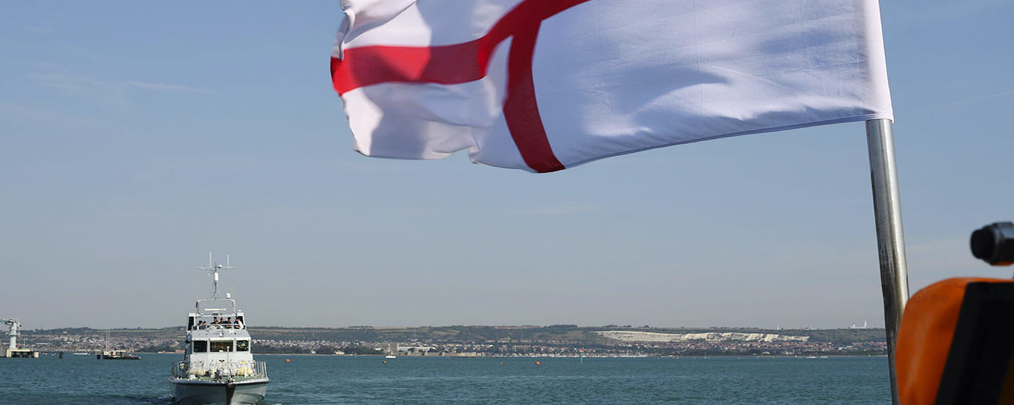 White Ensign raised with a P2000 ship sailing in the background