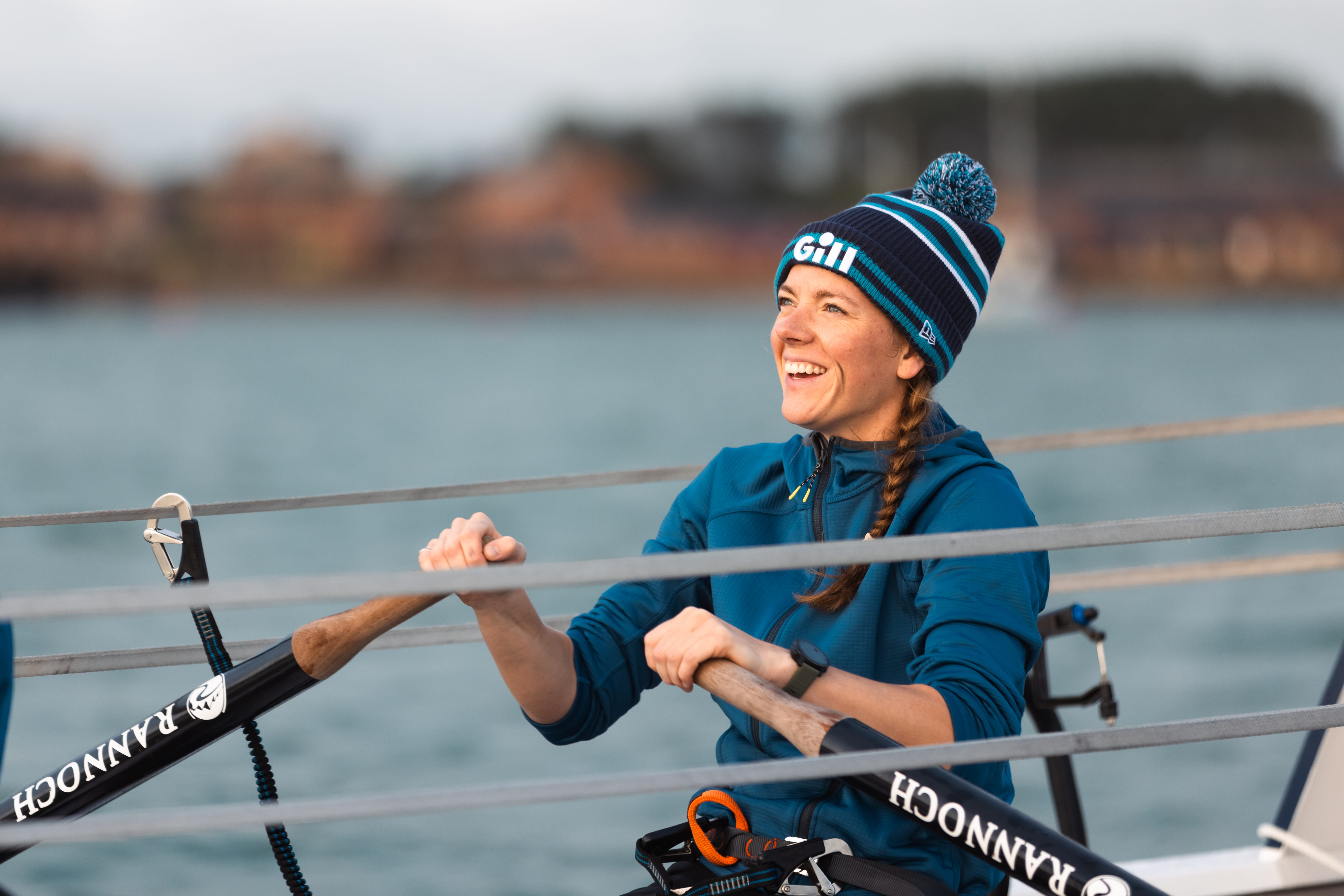 Female rower in a blue top and hat