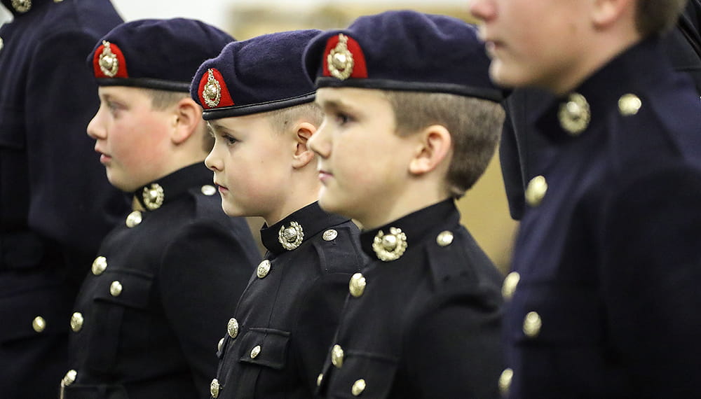Four Royal Navy cadets in black uniform