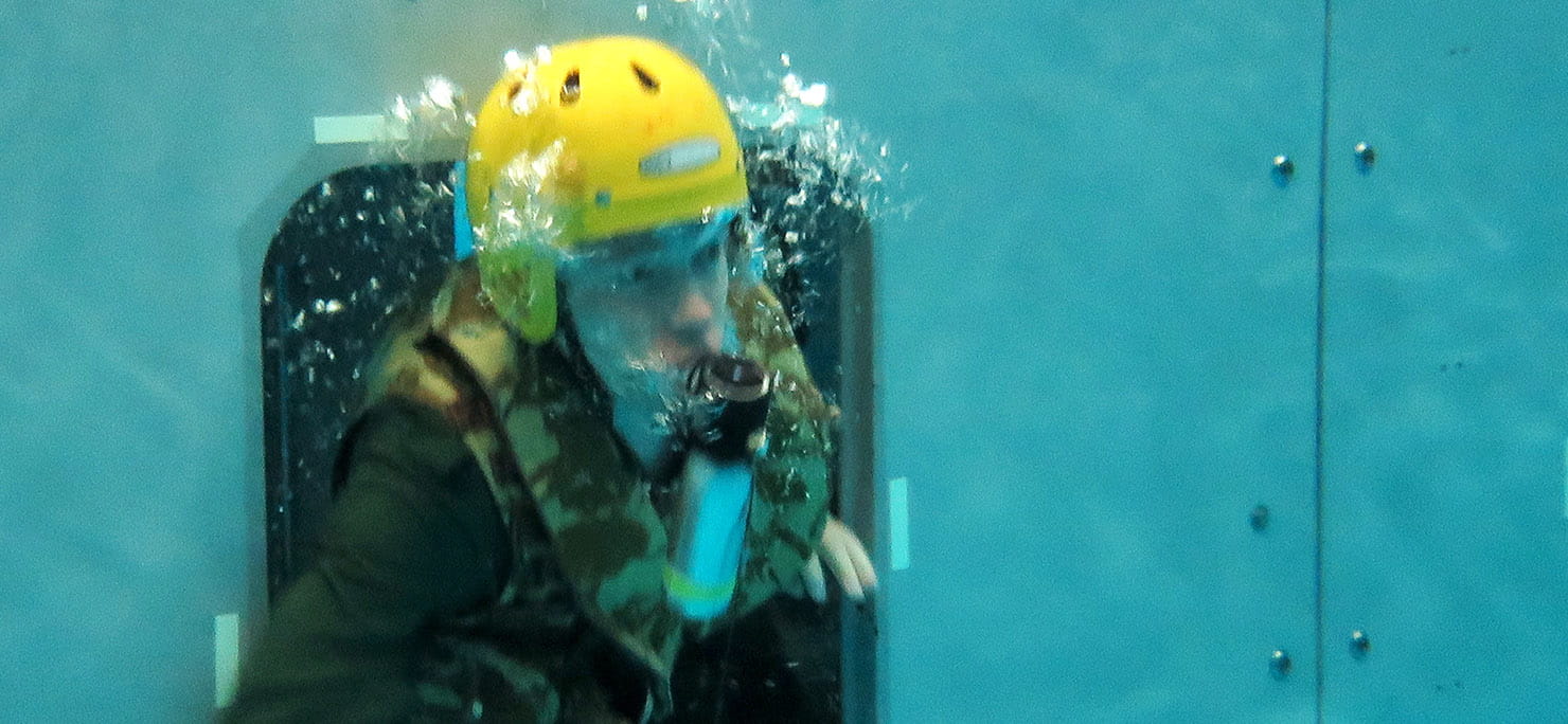 Personnel in swimming pool during the helicopter underwater escape training exercise using self-contained underwater breathing apparatus.