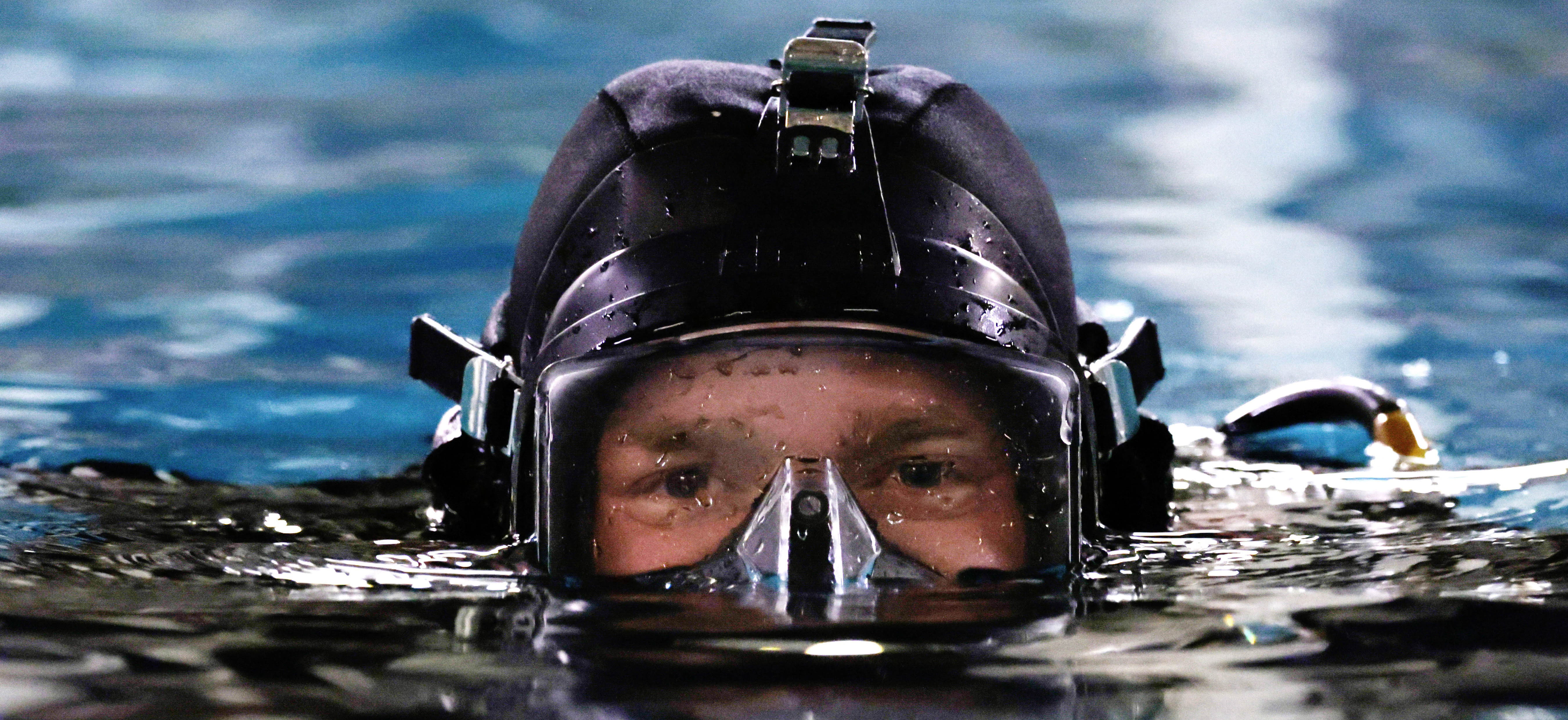 Royal Navy Diver emerges from water in diving equipment.