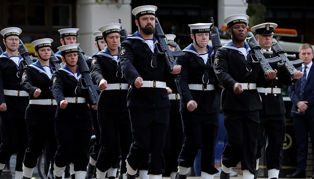 Eleven Royal Navy sailors holding guns on their shoulders
