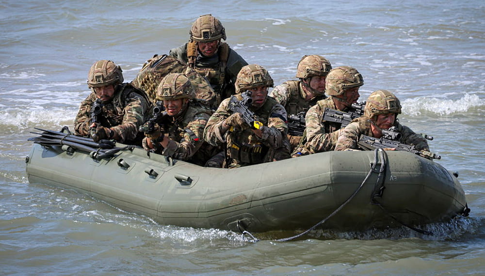 Seven Royal Marines wearing camouflage in an inflatable boat